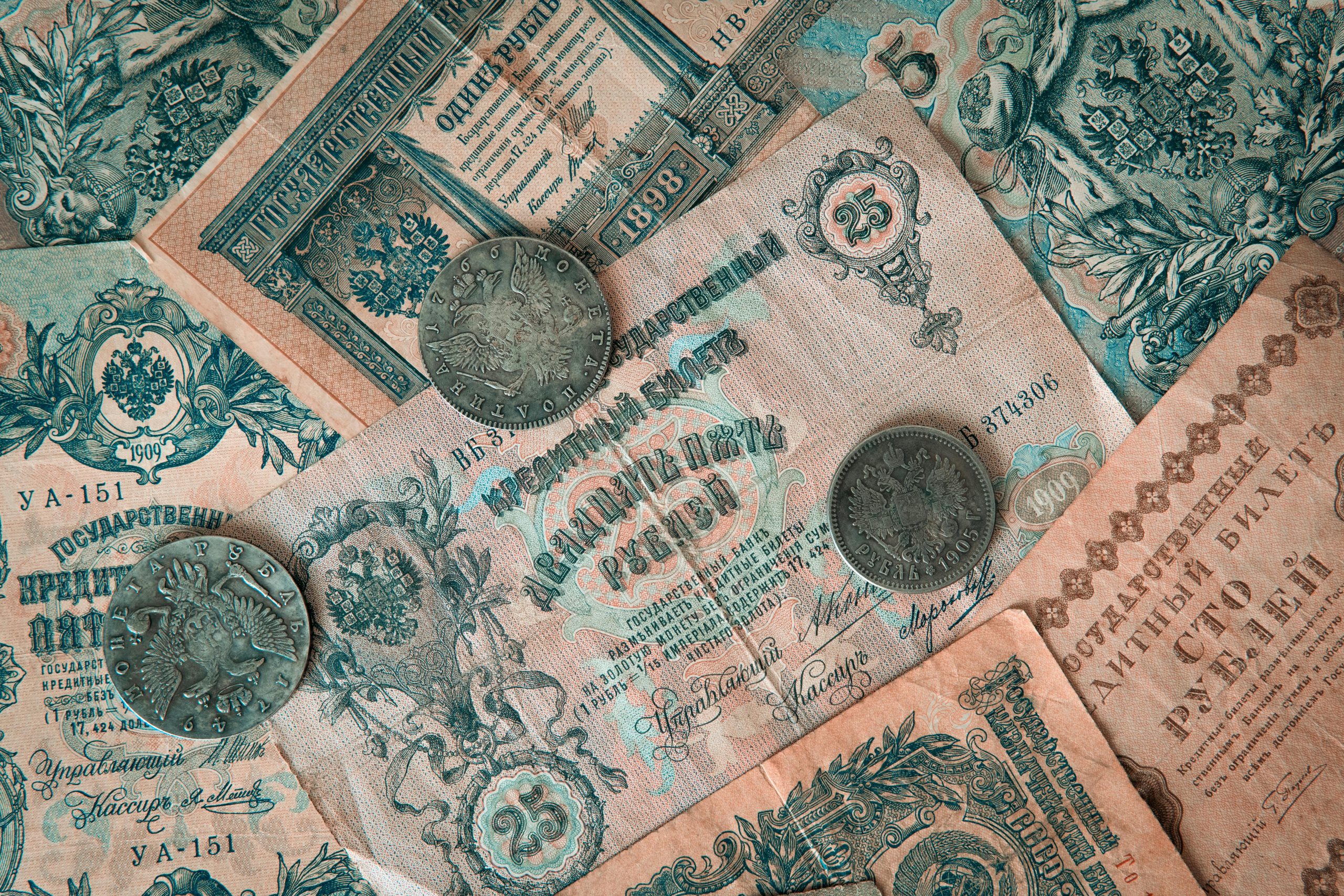 Collection of vintage Russian banknotes and coins featuring intricate designs.
